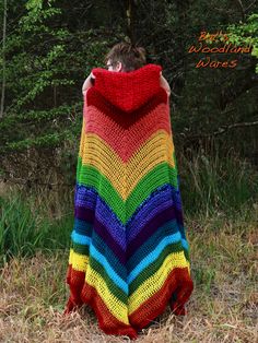 a woman wrapped in a multicolored crochet blanket