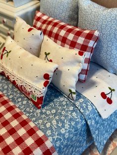 a bed with red and white checkered bedspread, pillows and pillow cases