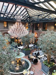 the inside of a restaurant with tables, chairs and chandelier hanging from the ceiling