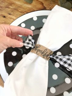 a person is holding onto a black and white polka dot plate with a name on it