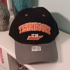 a black and gray hat with the word tennessee on it sitting on top of a white shelf