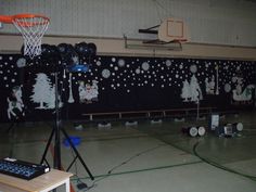 an indoor basketball court with christmas decorations on the wall and around it is a microphone set up