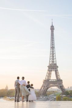 three people standing in front of the eiffel tower