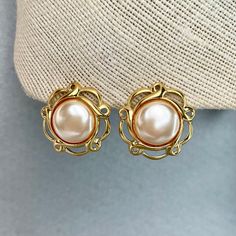 "Vintage Napier Pearl Cabochons Earrings, Gold Tone Cream White Filigree Earrings, Signed Estate Costume Jewelry, Gift for Her. Era: After 1955.  Designer: Napier.  Measurements:      - Length: 1 1/4\" inches.       - Width: 1 1/4\"inches.  Details: - Embellishments: Gold Tone Plating, Cream White Cabochons, filigree round shape Earrings.  - Closure: Push Backs.  Here are more Vintage Jewelry items for your viewing pleasure: https://etsy.me/2SGhTFo Our shop team members do our best to research and identify items correctly and do our best to point out and identify any issues with pieces. Please examine the pictures closely as these are part of the description. Please bear in mind that most of the pieces we offer are vintage and antique and will sometime have some minor wear and character. Y Vintage Gold-plated Hallmarked Earrings, Cos Jewellery, Vintage Gold-tone Clip-on Earrings For Evening, Retro Gold Clip-on Cabochon Earrings, Napier Jewelry, Vintage Yellow Gold Clip-on Pearl Earrings, Vintage Clip-on Costume Jewelry Earrings, Vintage Inspired Jewelry, Filigree Earrings