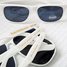 two pairs of white sunglasses sitting next to each other