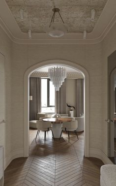 an archway leads to a dining room with chairs and a table in the center, along with a chandelier hanging from the ceiling