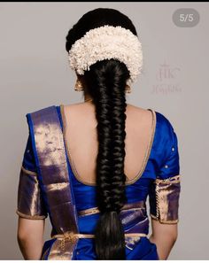 the back of a woman's head with long black hair in a blue dress