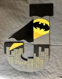 the letter j is made out of cardboard and has a batman symbol on it