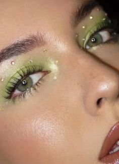 a woman with green eyeliners and glitter on her eyes