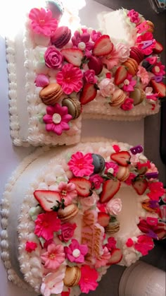 there are two cakes decorated with flowers and fruit