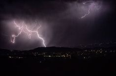 lightning strikes in the night sky over a city