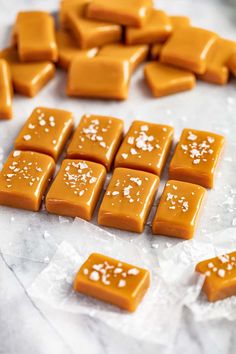 there are many pieces of caramel candy on the table with white flecks