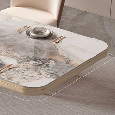 a marble dining table with two plates and silverware on it, in front of a beige chair