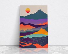 an abstract painting with mountains and the sun in the distance on a white wall above it