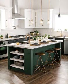 a kitchen with white cabinets, green island and gold accents on the countertops is shown