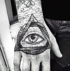 a hand with an all seeing eye tattoo on it