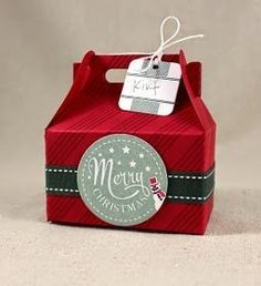 a small red box with a tag on it that says merry christmas in white lettering