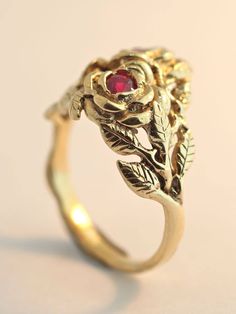 Two detailed roses make up this elegant ring, their stems entwining and forming the band. The ring is cast in solid 14K gold and two 3 mm rubies are set in the center of each rose. Indulge yourself or someone special in this sparkling bouquet. We will contact you to let you know if we have your chosen ring size in stock or when to expect shipment. All Marty Magic Jewelry is packaged in a beautiful ring box embossed with the gold foil Marty Magic dragon logo. Perfect for any occasion! Designed in Rose Flower 14k Gold Anniversary Ring, Vintage Rose Jewelry For Anniversary, Formal Rose Flower Shaped Rings, Vintage Rose-colored Jewelry For Anniversary, Formal Rose Flower Rings, Formal Rose Colored Flower Shaped Rings, Formal Flower Shaped Rings With Rose Design, Elegant Gold Rings With Rose Details, Formal Flower-shaped Ring With Rose Design