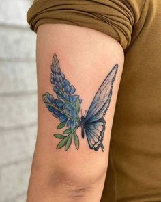 a woman's arm with a blue butterfly and flowers tattoo on the left side of her arm