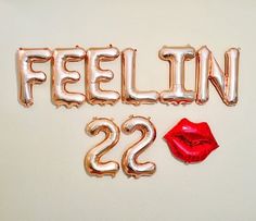 balloons spelling out the word feelin'22 with a red lipstick