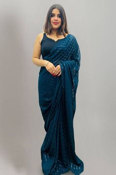 Elegance and honourable come together in this beautiful drape. Add grace and charm towards the look in this pretty Teal Blue georgette traditional saree. The Saree is elevated with Sequins embroidery. Comes with matching blouse. (Slight variation in color, fabric & work is possible. Model images are only representative.) Fabric DetailsBlouse: GeorgetteSaree: GeorgetteBlouse Piece Length: 85cm meterSaree Length: 6.3 meter NOTE: The blouse worn by the model in the photo is not included. You will r Sequin Saree, Fabric Work, Teal Blue Color, Model Images