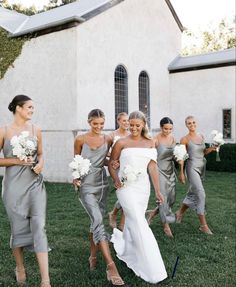 the bride and her bridesmaids are walking in front of an old white church