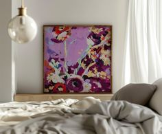 a painting is hanging on the wall above a bed