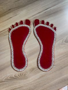 a pair of shoes that are on top of a wooden floor with beads and pearls