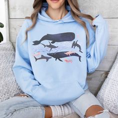 Ocean Animal sweatshirt. This is a soft hoodie with original watercolor design of whales, hammerhead sharks, school fish, and jellyfish - great for marine biology gift, ocean life hoodie, of save the ocean sweatshirt. This unisex heavy blend hooded sweatshirt is relaxation itself. Made with a thick blend of cotton and polyester, it feels plush, soft and warm, a perfect choice for any cold day. In the front, the spacious kangaroo pocket adds practicality while the hood's drawstring is the same color as the base sweater. Inks are water based, bio-degradable and non-toxic. **How to Order (check and review the photos for more info): 1. Select a size (For a looser fit, choose 1-2 sizes up) 2. Select a color 3. Add to cart Processing time is typically 1-3 days Shipping time is typically 3-5 days Casual Long Sleeve Sweatshirt With Shark Design, Ocean Sweatshirt, Hammerhead Sharks, Sea Life Animals, Save The Ocean, Shark Hoodie, Animal Hoodie, Animal Sweatshirt, Sea Animal