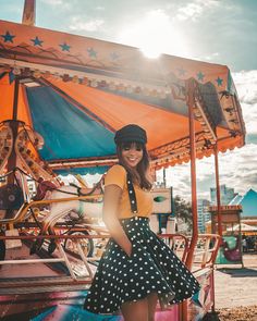 a woman standing in front of a carousel