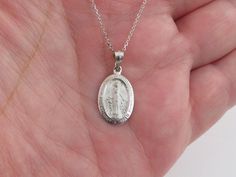 "A Fabulous 14k White Gold Virgin Mary Necklace!! Please pay attention to the size and the length. This pendant is small. If you need more photo please message me.  * Material: 14k solid gold, Not plated or filled * Length: 5/8\" or 17 mm long not including the bail  * Width:  3/8\" or 10 mm wide * Cable Chain: 16\", 18\", 20\" long by 0.8 mm thick with lobster clasp. * Length And avg weight: 16\" = 2.20 g , 18\"= 2.40 g , 20\"= 2.60 g * Complementary Gift Box included  There is a prayer around Dainty Silver Necklace With Miraculous Medal, White Gold Necklace With Miraculous Medal For Gift, Elegant Sterling Silver Necklace With Miraculous Medal, White Gold Necklace With Miraculous Medal As Gift, Sterling Silver Miraculous Medal Necklace As Gift, White Gold Miraculous Medal Jewelry In Sterling Silver, Round Miraculous Medal Necklace For Anniversary, Miraculous Medal Jewelry Gift, Anniversary Necklace With Miraculous Medal Pendant