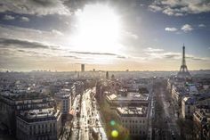 an aerial view of the city of paris, france at sunset with sun shining over the eiffel tower