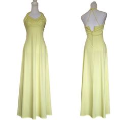 Embrace the vintage beauty of this stunning light yellow halter dress, perfect for any evening occasion. The dress features an open back design and flows elegantly to a length of 58-59 inches from shoulder to hem. Made of high-quality knit polyester material, this original dress is a size 2 and fits perfectly for a regular size type.  The dress is a perfect representation of the bohemian look with a touch of elegance, making it a unique addition to any wardrobe. It is an original piece manufactured in the United States by UNIONMADE brand. The dress is perfect for anyone who wants to add a touch of vintage glam to their fashion style. Empire waist Light yellow Modern size 2 Floor length Clips behind neck Halter neckline Open back Triangle strap detail V-neck Rear nylon zipper Minor flaws: f Summer Backless Maxi Dress For Dinner, Summer Halter Neck Backless Dress For Dinner, Vintage Backless Party Dress, Spring Evening Halter Dress With Back Opening, Yellow Halter Neck Maxi Dress For Party, Yellow Halter Neck Maxi Dress For Evening, Yellow Backless Maxi Dress For Party, Yellow Backless Maxi Dress For Evening, Summer Floor-length Halter Dress With Back Opening