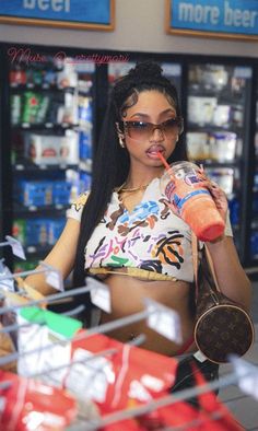 a woman in a store drinking from a bottle and holding a bag behind her back