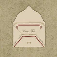 a white envelope with a red ribbon on the front and bottom, sitting against a wallpapered background