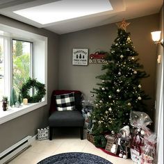 a living room with a christmas tree in the corner and other decorations on the floor