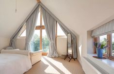 a bedroom with a bed, dresser and large window