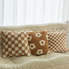 four pillows on a couch in front of a window