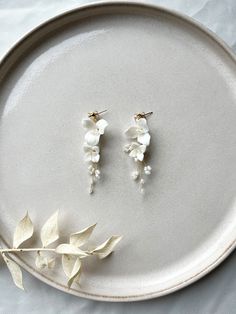 Are you looking for floral bridal earrings? You'll find them here! These earrings made of white ceramic flowers are a real eye-catcher and perfect as bridal jewelry! Stud earrings made of 316L stainless steel jewelry wire Pearls and fine ceramic flowers For more jewelry inspo, check out our shop! You can also find matching hairpins here 🤍 Photos: dark-haired model: Diana Alyasin Blonde model: Janine Klebolte 💫 White Dangle Flower Earrings With 3d Flowers, White Dangle Earrings With 3d Flowers, White 3d Flower Dangle Earrings, White Dangle Jewelry For Bride, White Pearl Drop Bridal Accessories As A Gift, White Dangle Jewelry For The Bride, White Dangle Earrings For Brides, White Bridal Accessories With Pearl Drop For Gift, Flower-shaped White Jewelry For Wedding