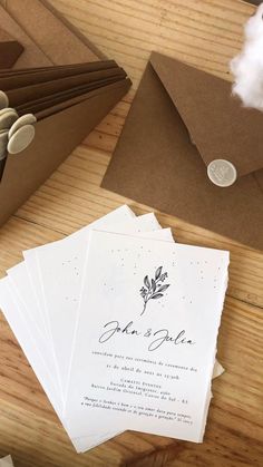 the wedding stationery is laid out on top of brown envelopes