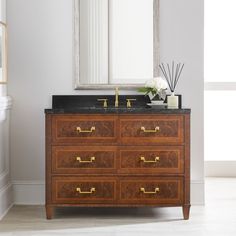 a bathroom vanity with marble top and wooden drawers