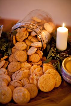 some cookies are on a table with a lit candle