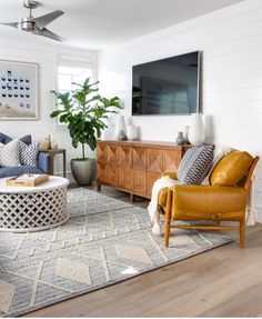 a living room filled with furniture and a flat screen tv mounted to the side of a wall