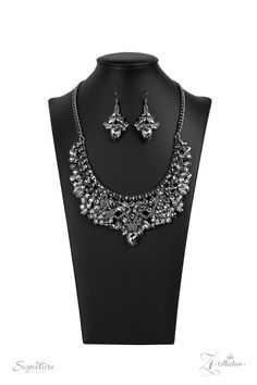 An infinite display of smoky marquise cut rhinestones and dazzling hematite rhinestones meticulously join into three dramatically dazzling frames below the collar. Attached to classic gunmetal chains, the dauntless display of dazzle cascades into an oversized smoky teardrop at the bottom, stealing the spotlight. Features an adjustable clasp closure.

Named after 2020 Rock the Runway winner, Tina P.

 Sold as one individual necklace. Includes one pair of matching earrings. Homemade Chinese, Sparkle Fashion, Jewelry Making Business, Jewelry Organizer Wall, Signature Necklace, Prom Accessories, Hematite Necklace, Beaded Tassel Necklace, Sparkly Jewelry