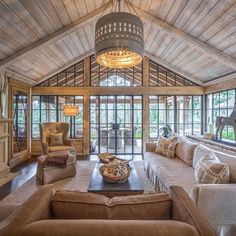 a living room filled with lots of furniture next to a fire place under a chandelier