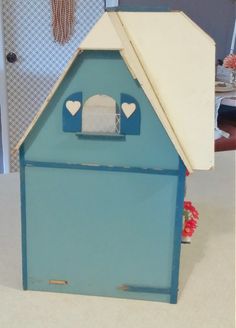 a blue and white dollhouse with hearts on the roof