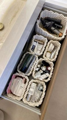 an open drawer in a bathroom filled with toiletries