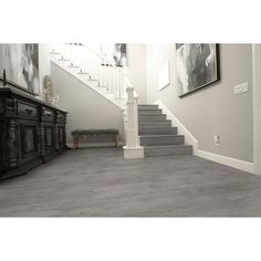 a staircase leading up to a living room with gray carpet