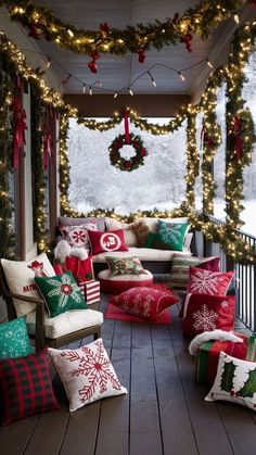 a porch decorated for christmas with red and green pillows