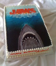 a birthday cake with a shark on it's face and the words jaws written in red